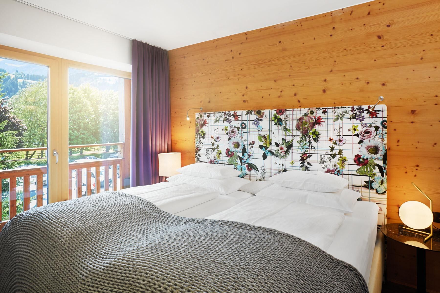A cozy bedroom with a large bed and a colorful headboard.
Large windows let in plenty of daylight and offer a beautiful view of nature.
